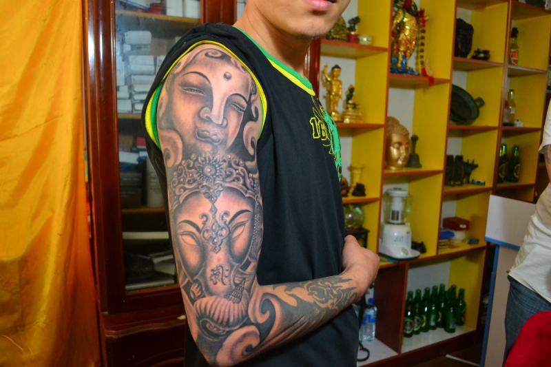 帅哥个性花臂佛首和象神纹身图案