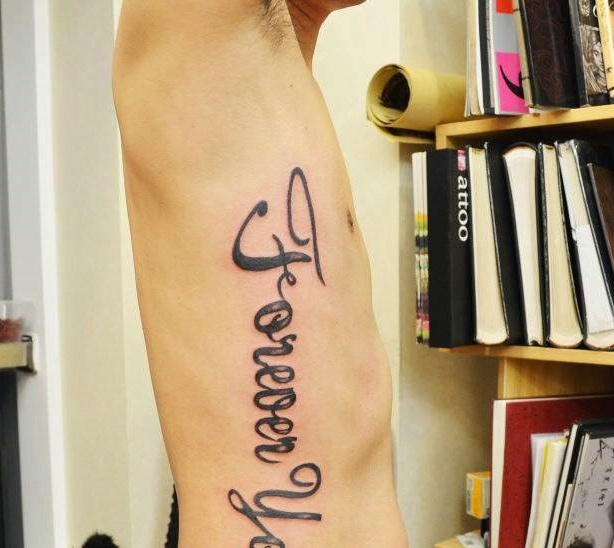 细腰男孩侧腰部的大型英文单词刺青