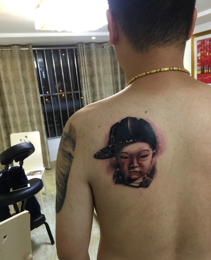 慈祥父亲把自己的小孩肖像纹在身上