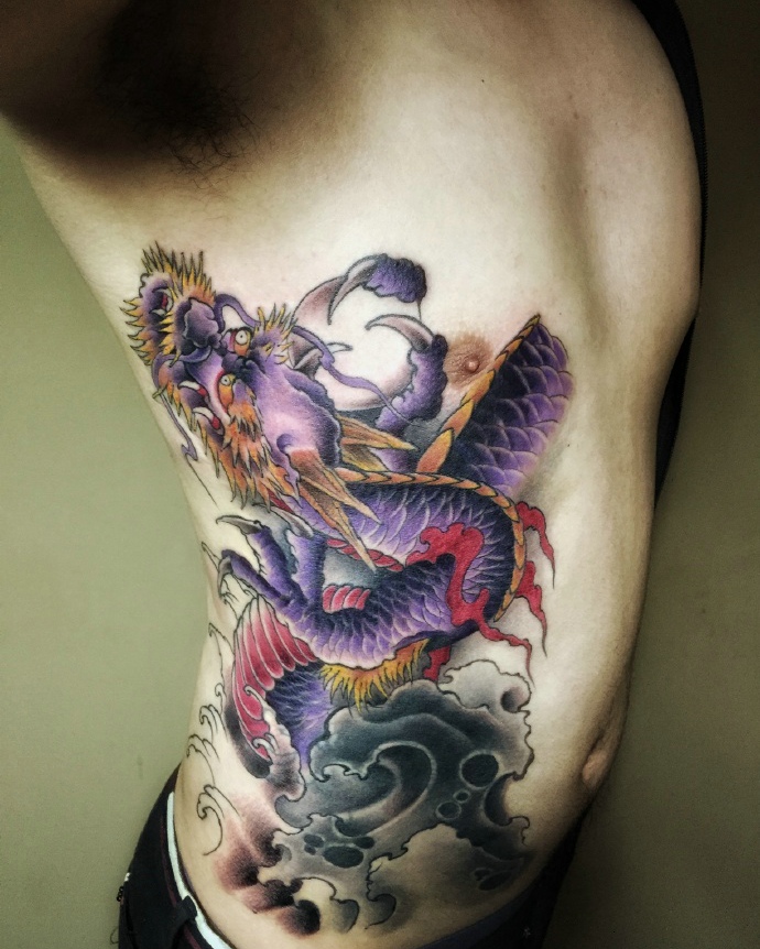 处在男士侧腰部的彩色邪龙纹身图案