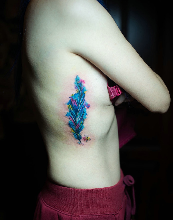 裸体美女侧腰部的彩色羽毛纹身图片