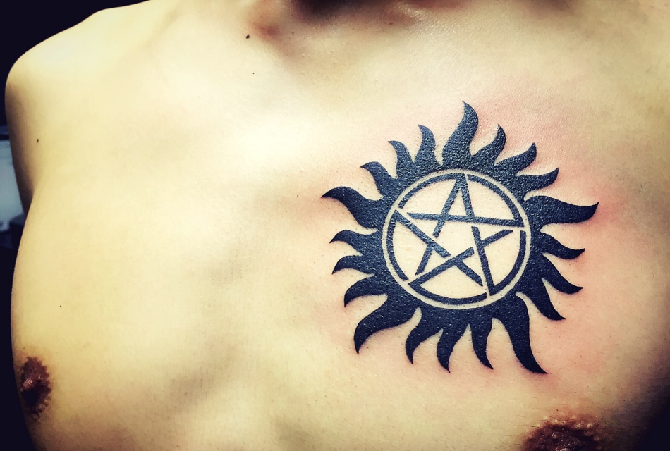 处在胸口的五角星小太阳纹身图案
