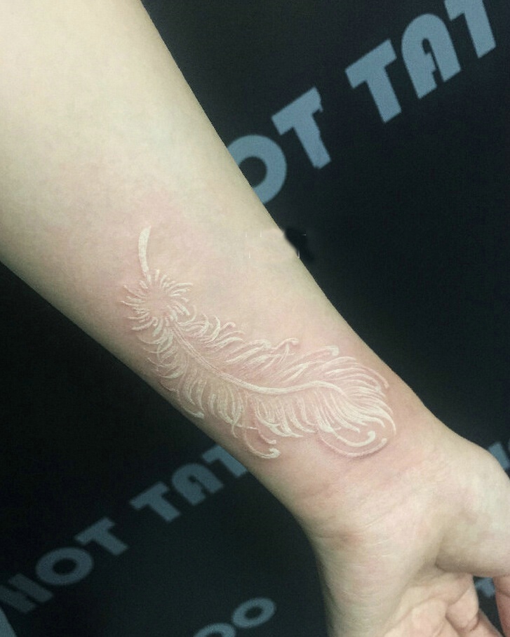手腕隐约能看见的隐形羽毛纹身图案