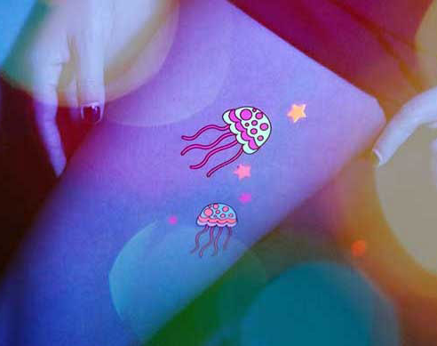 女孩大腿上的可爱彩色荧光水母纹身