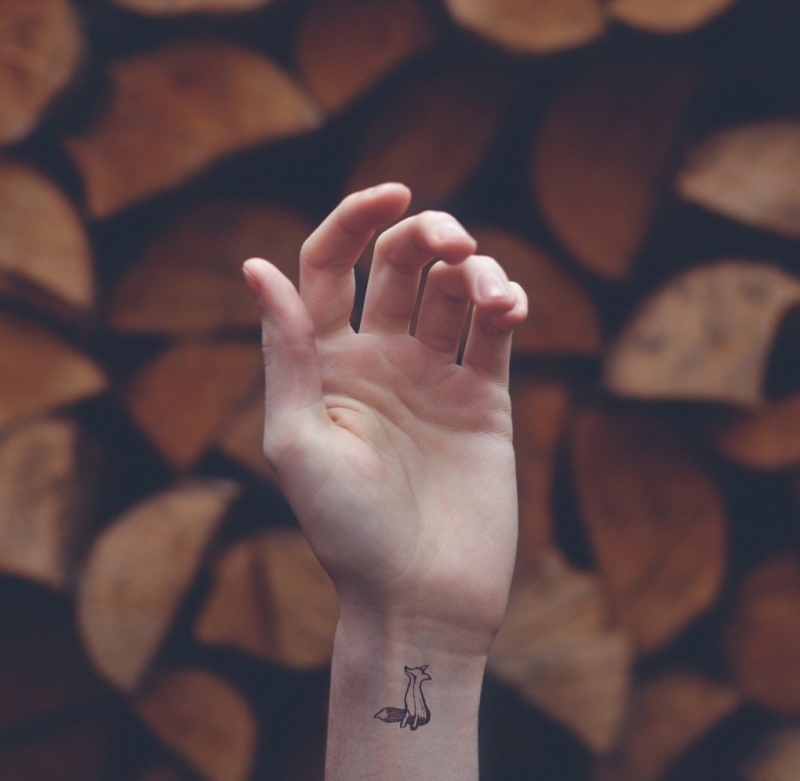 女子手腕上的红色小狐狸图案纹身