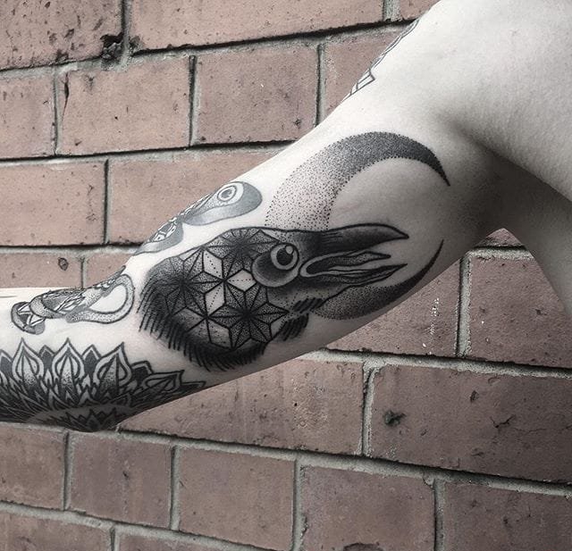 小腿上带有人脸的太阳纹身图案