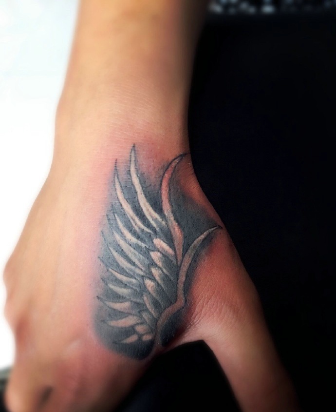 手背个性独特的半边羽毛纹身图案