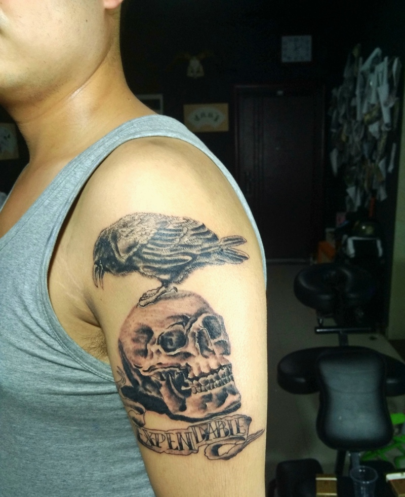 站在骷髅头上的小鸟手臂纹身图案
