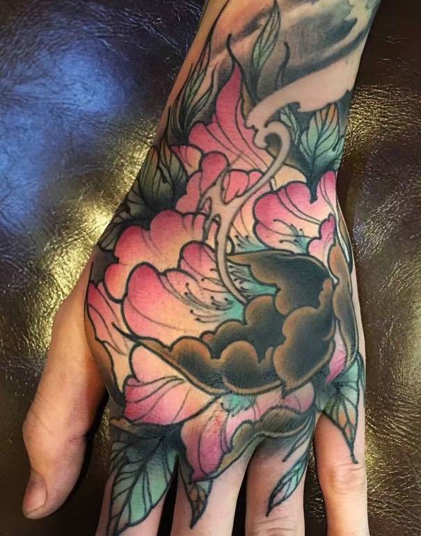 遮盖手背色彩不一的花朵纹身刺青