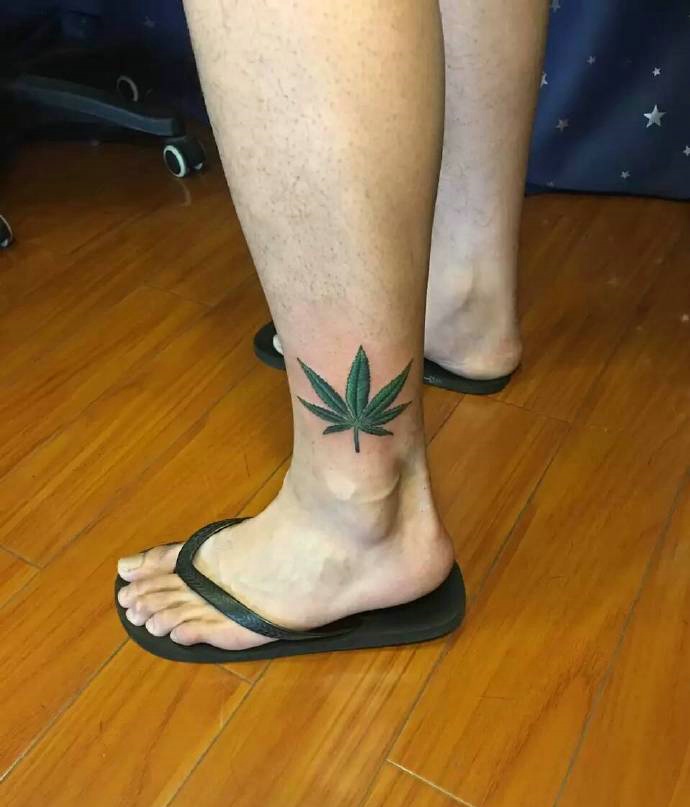 遮盖小腿一小部分的一片绿叶子纹身图案