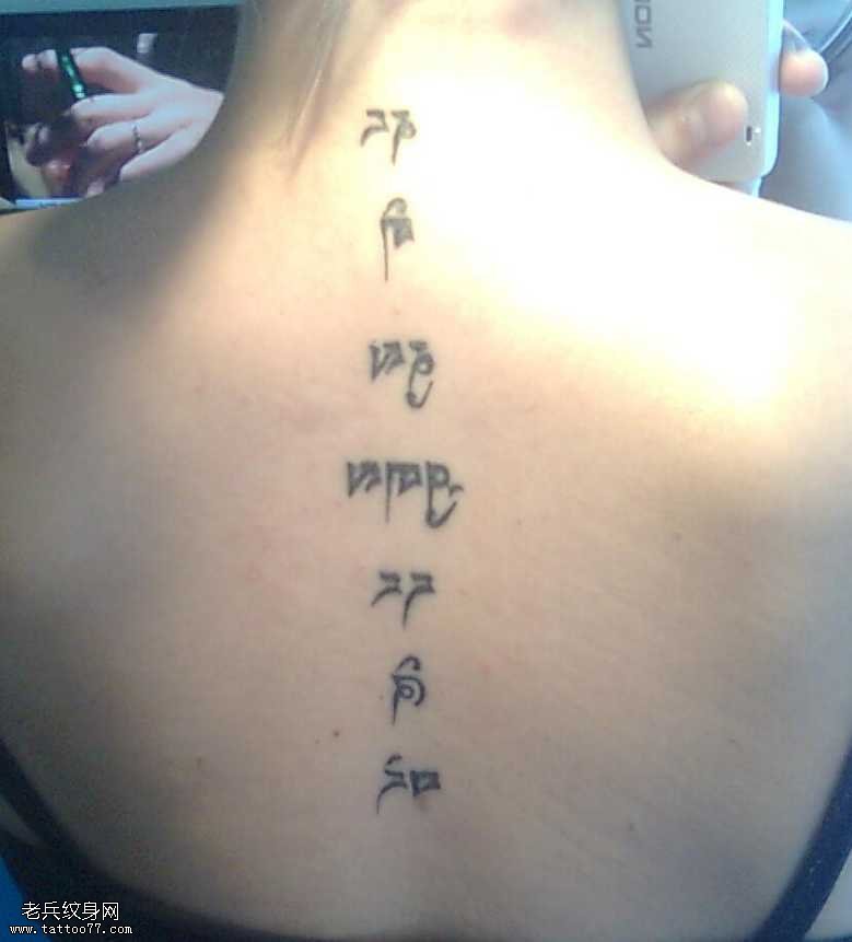 背部神秘字体亲吻女生的纹身图案