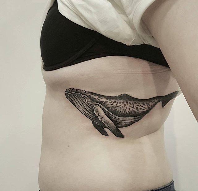 男子侧肋上的带着夜景图案的鲸鱼纹身图案