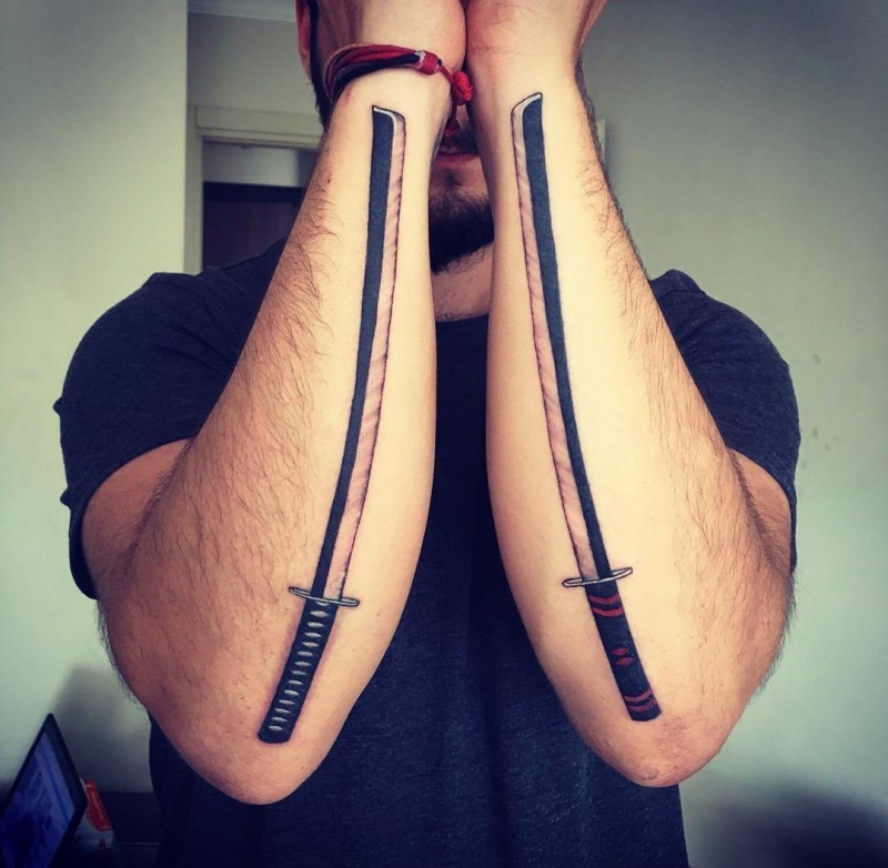 男子双手前臂上的武士刀纹身图案