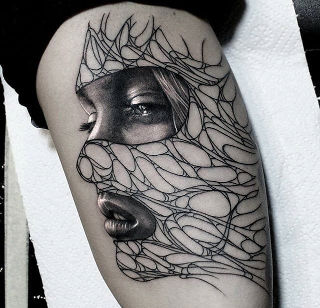 大腿上的女子面部线条纹身图案