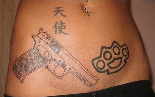 女孩大腿上的环形初边和手枪纹身图案