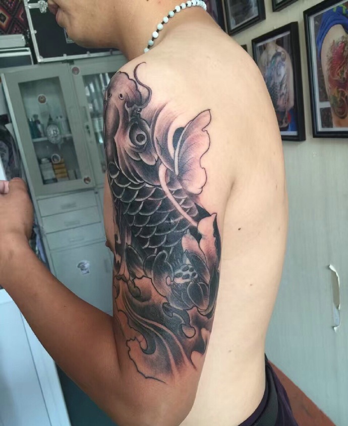 莲花与鲤鱼的大臂黑白纹身图案
