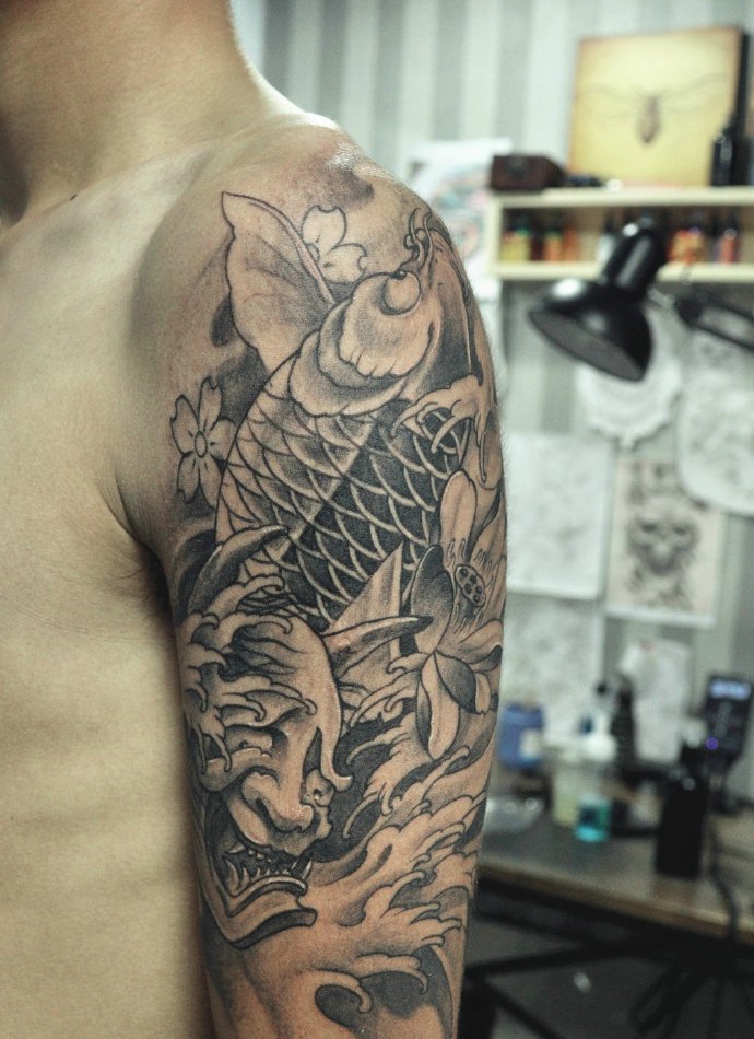 莲花与鲤鱼的大臂黑灰纹身图案