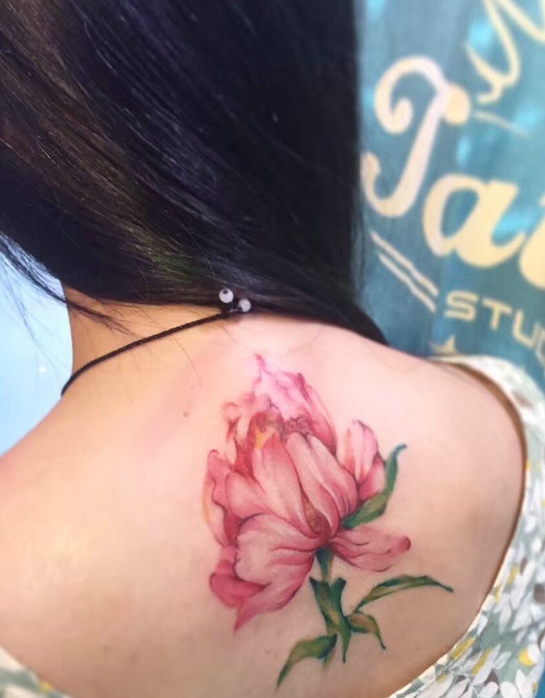 长发女子脊椎部鲜艳花朵纹身图案