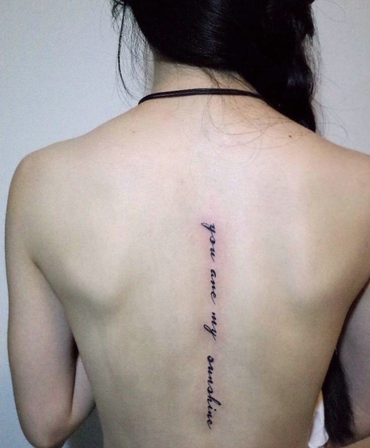 处在脊椎部细小的英文纹身图案