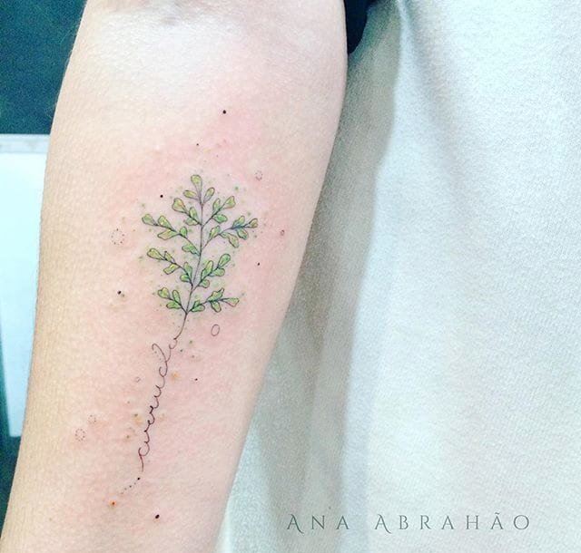 女性手臂上的浅彩色微型树纹身图案