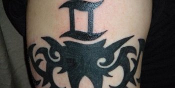 男子手臂上的黑色环形梵文纹身图案