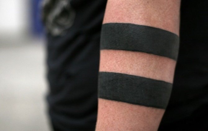 男子手臂上的黑色环形梵文纹身图案