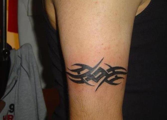 男子手臂上的黑色环形梵文纹身图案