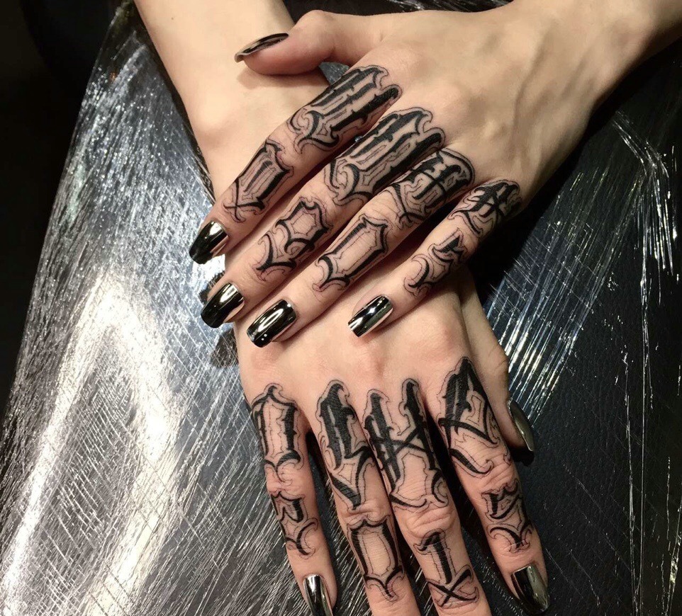 黑色指甲搭配着黑色花体纹身图案