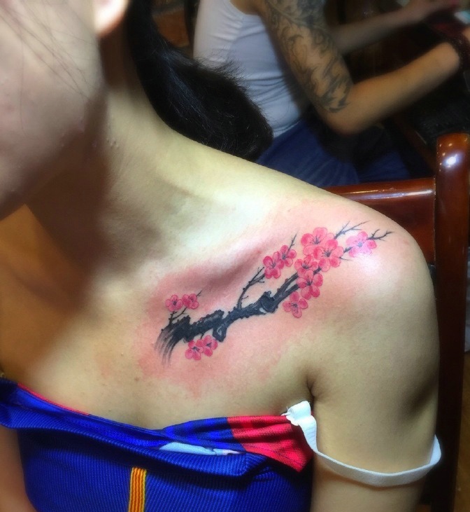 蓝衣女子锁骨漂亮的梅花纹身图案