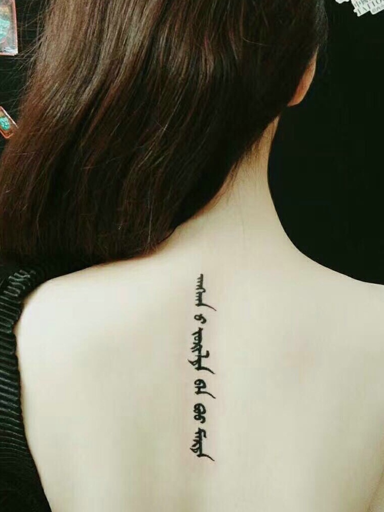 长发女生脊椎部梵文纹身图案