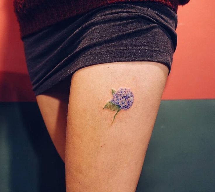 女性左大腿上淡雅的紫色小花纹身图片