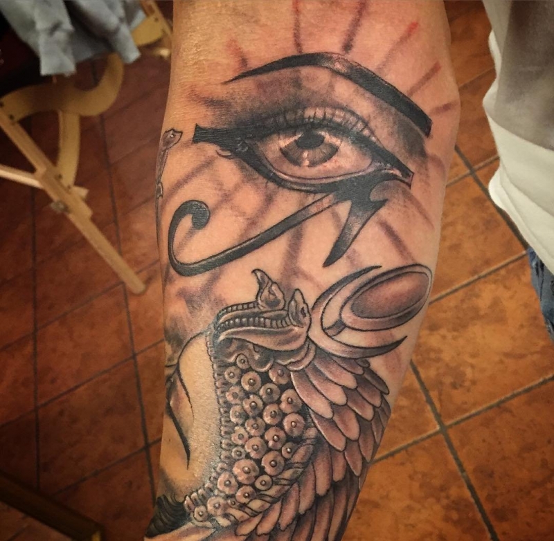 右手臂上的黑灰色荷鲁斯之眼和埃及风格头饰纹身图案