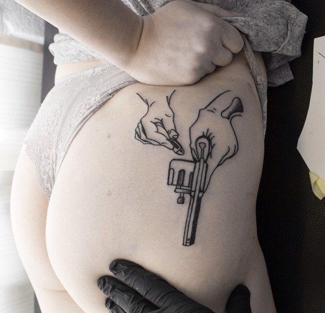 性感女性臀部上的手枪纹身图案