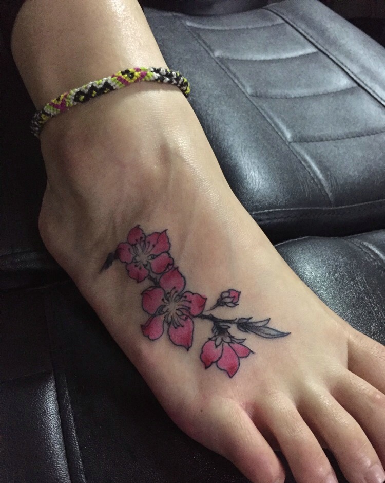 脚背上的彩色花朵纹身图案很抢眼