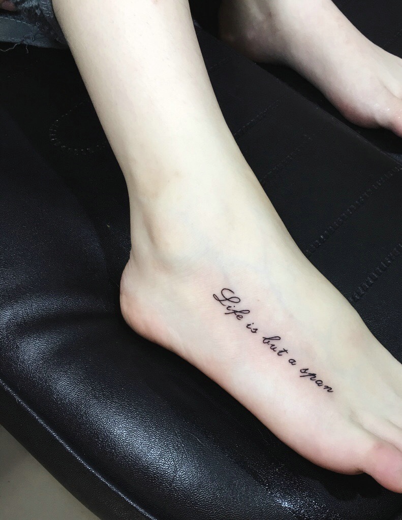 时尚女孩脚背上有着时尚英文纹身图案