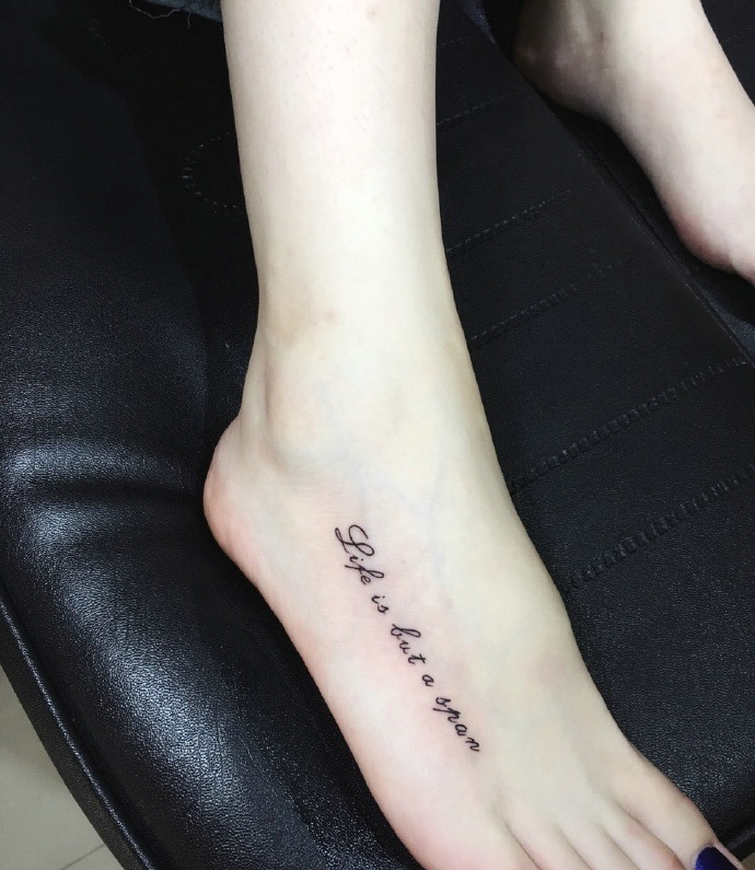 时尚女孩脚背上有着时尚英文纹身图案