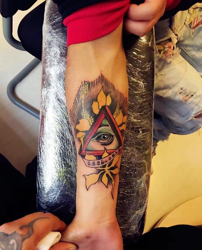 手臂颜色不一的几何眼球纹身图案
