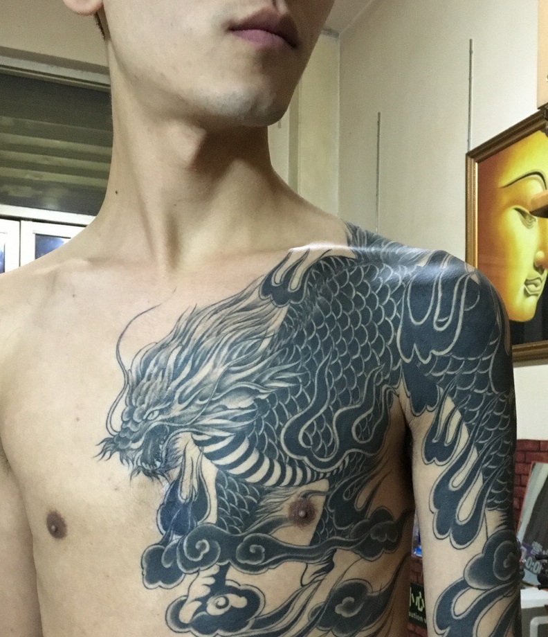 阳光男孩有着半甲邪龙纹身图案