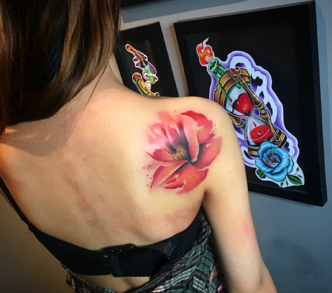 长发女孩后背落着一朵花纹身图案