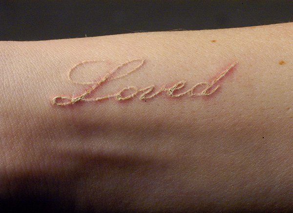 手臂上个性的白色隐形纹身图案