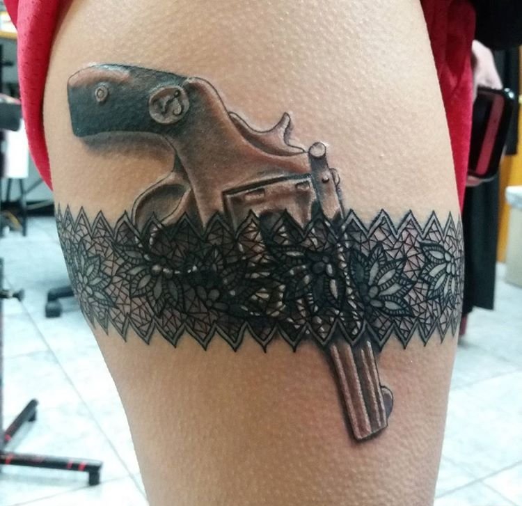 女性大腿性感的吊袜带和手枪纹身图片