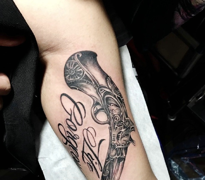 手臂内侧水枪与英文一起的纹身图案