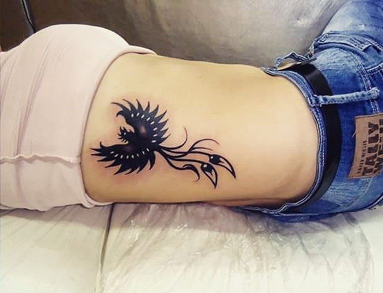 女性侧肋上漂亮的凤凰纹身图案