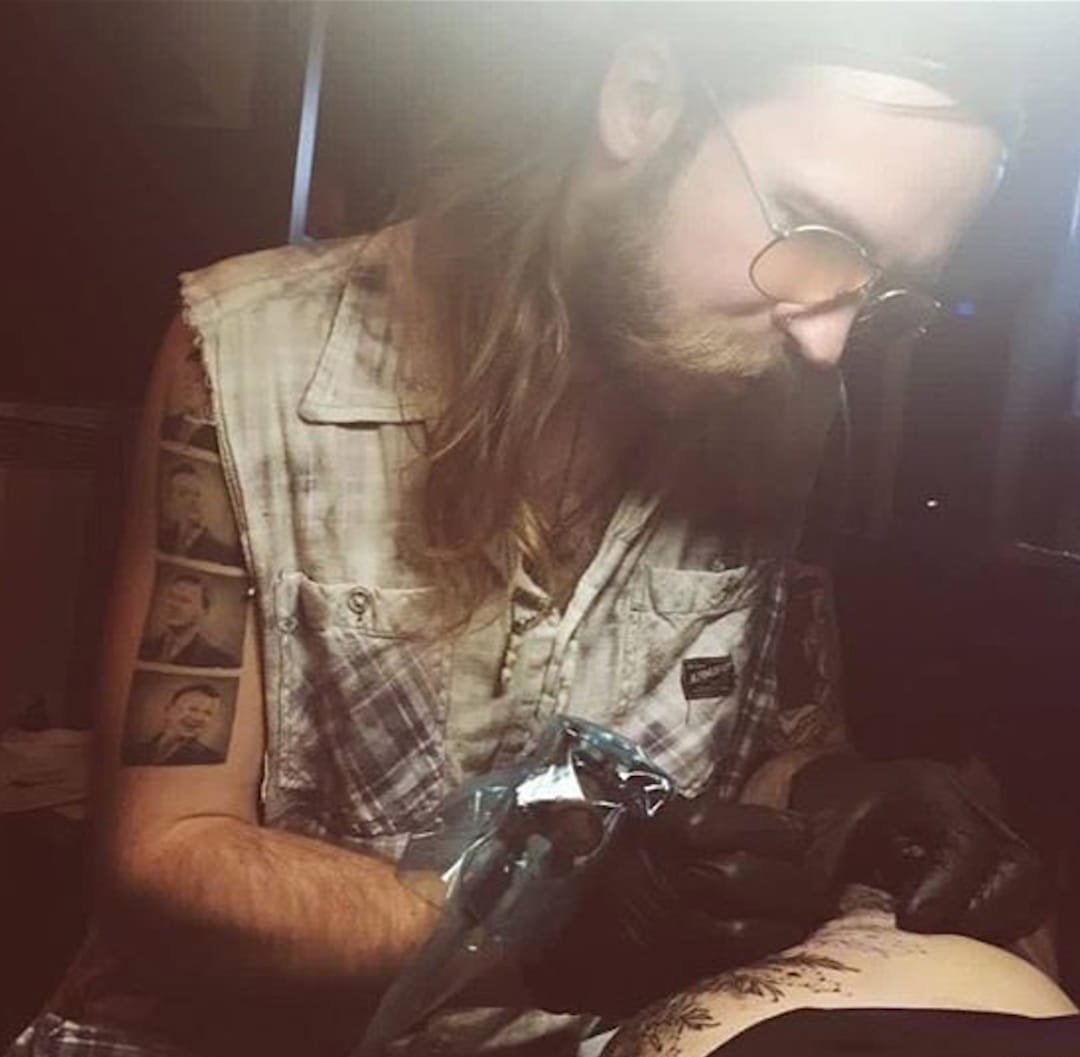 黑色的植物树叶和花纹身图案来自于纹身师泰德