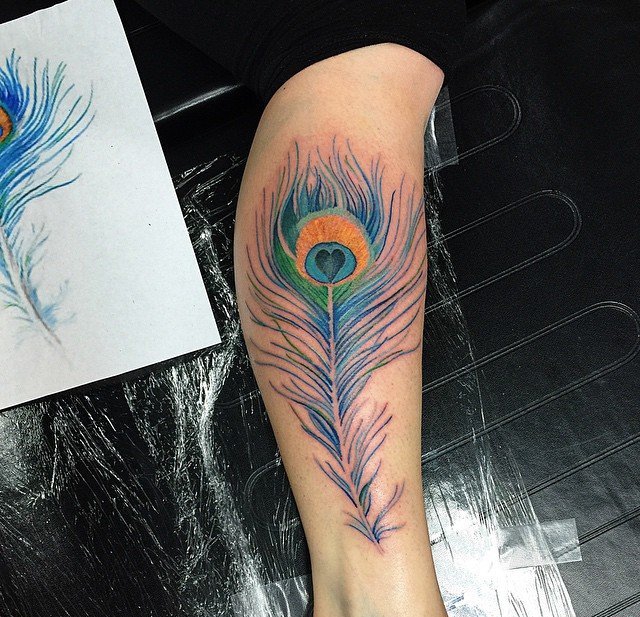 女性小腿脚背上漂亮的孔雀羽纹身图案