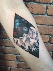 手前臂上的菱形里的彩色星空山峰和树木纹身