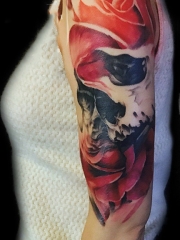 手臂写实的骷髅与红玫瑰纹身图案