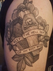 手大臂膀上的黑灰色英文横幅和骷髅头棺材纹身图片