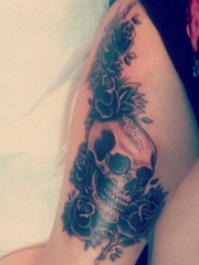 女性性感大腿上的黑色玫瑰花朵和骷髅头纹身