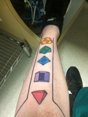 小腿上的个性的多种颜色的几何立体图形纹身